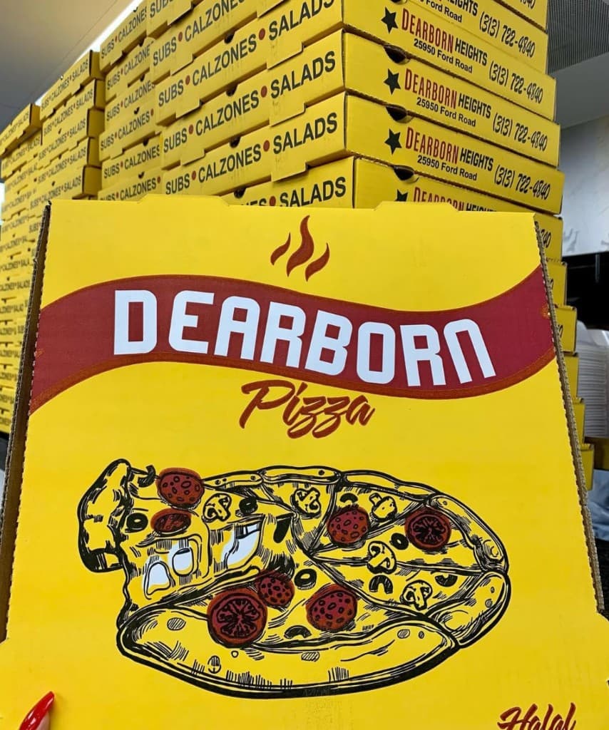 Stack of yellow Dearborn Pizza boxes with Halal branding and Dearborn Heights address on the side