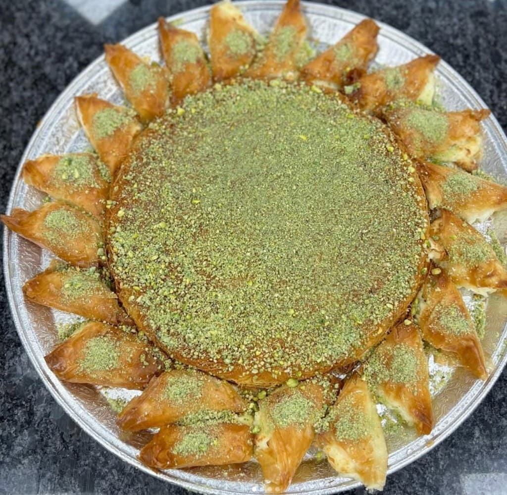Platter of Middle Eastern pastries including kunafa and phyllo triangles with pistachio